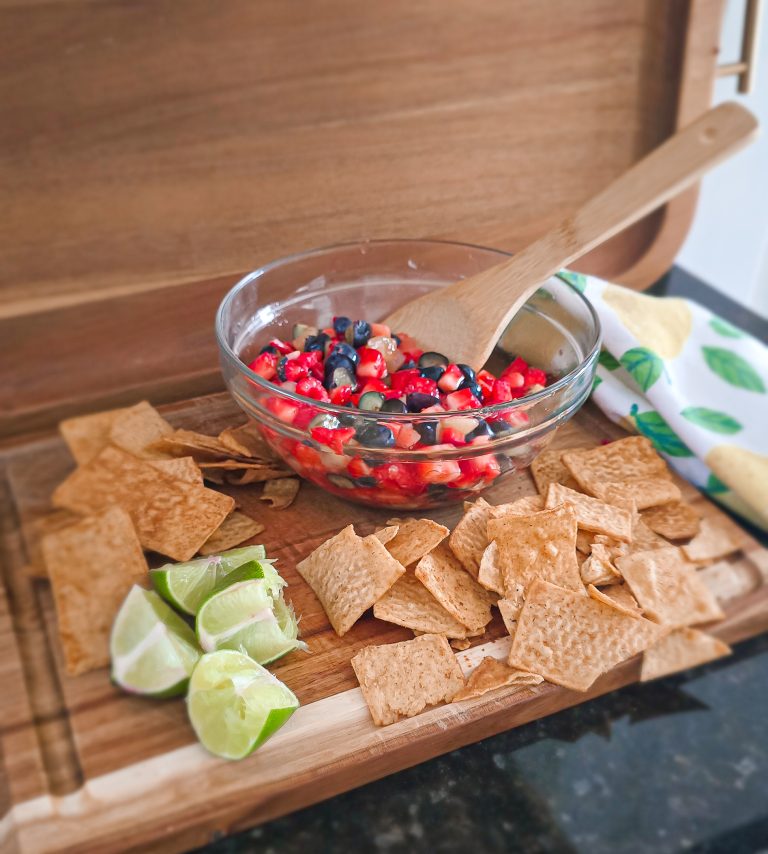 fruit salsa with churro chips and lime on a wooden cutting board