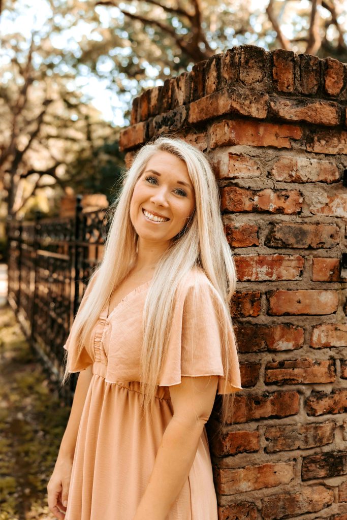 girl leaning against a brick column