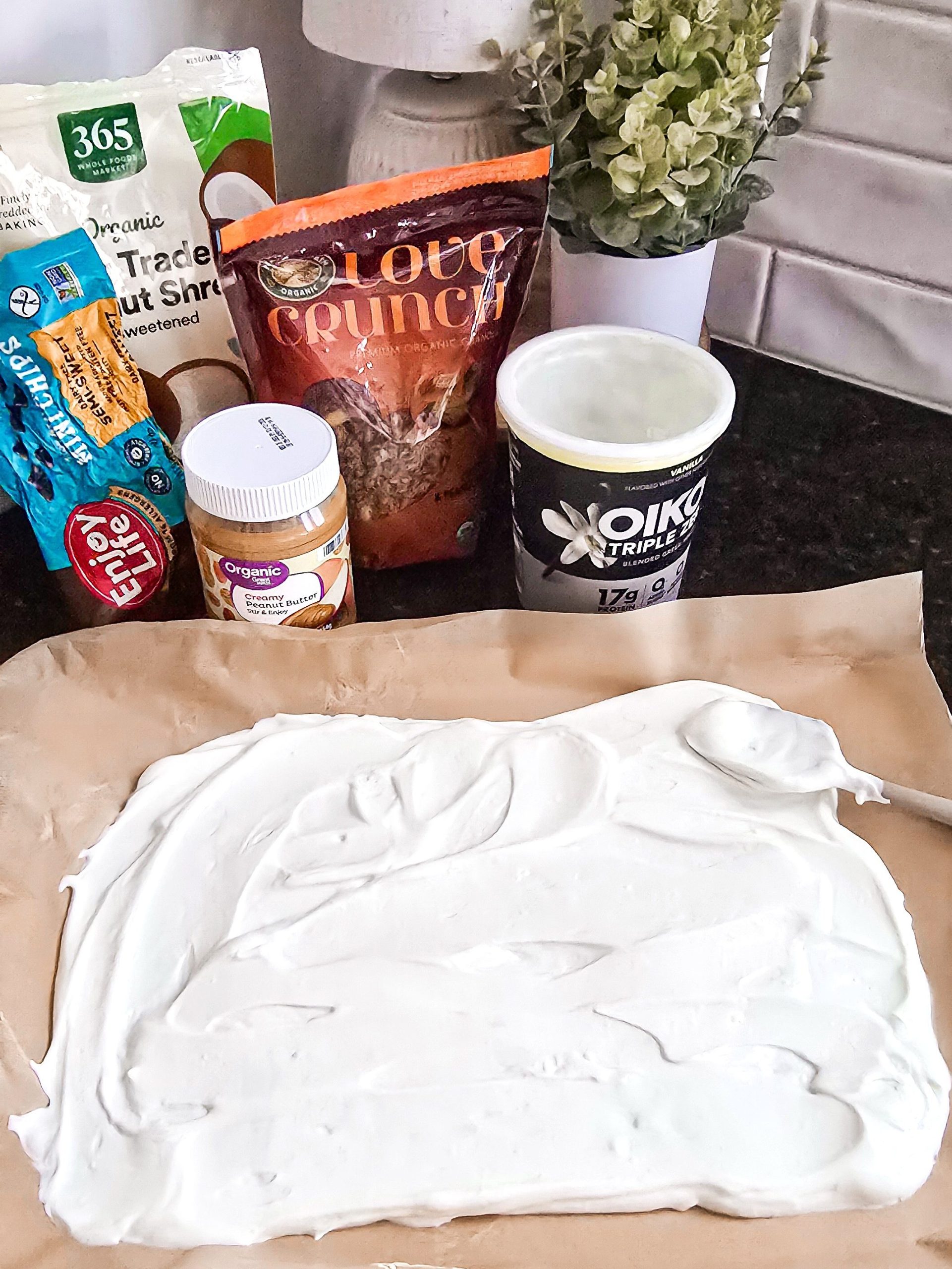 Yogurt spread onto parchment paper with topping in background