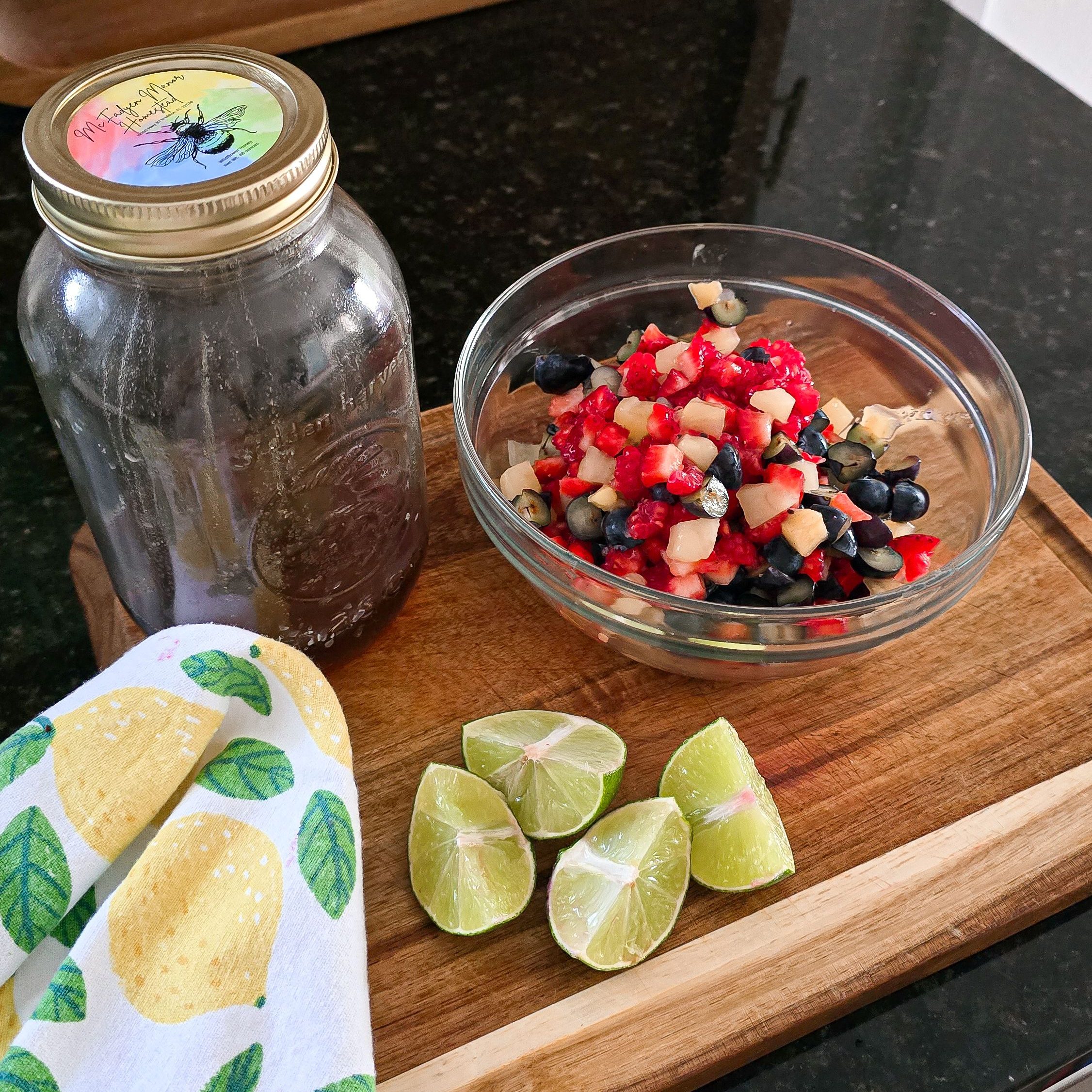 fruit salsa on a cutting board with lime and honey